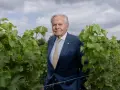 Bernard Magrez, un homme d'affaires visionnaire, pose au milieu de ses vignes luxuriantes, un symbole de son héritage viticole.