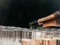 Une bouteille de champagne verse son contenu pétillant dans une rangée de flûtes. Le début d'une célébration avec le meilleur champagne du monde.