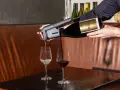 Un appareil verse du vin rouge dans un verre, à côté d'un verre de vin blanc. Parfait pour choisir entre vin rouge, blanc ou rosé.