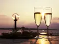 Deux flûtes de le meilleur prosecco scintillent au soleil couchant, accompagnées d'une assiette d'amuse-bouches.