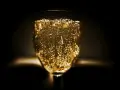 Un verre de vin mousseux scintillant, rempli de bulles dorées, prêt à célébrer.