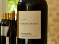 Bouteille de vin rouge Château Fleur Haut Gaussens, Bordeaux Supérieur, avec d'autres bouteilles en arrière-plan.