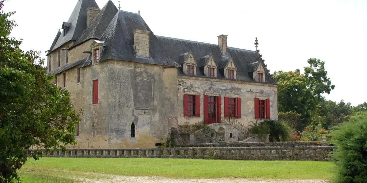 Le **château Olivier**, une bâtisse de pierre aux volets rouges, se dresse fièrement entouré de verdure.