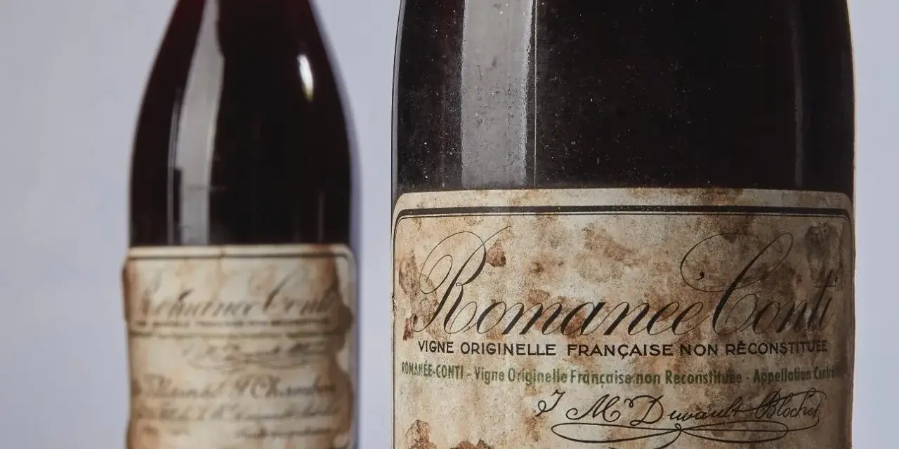 Deux bouteilles de vin Romanée-Conti, dont une avec une étiquette ancienne et jaunie.