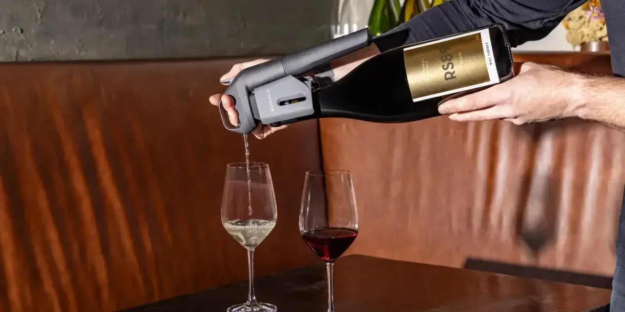 Un appareil verse du vin rouge dans un verre, à côté d'un verre de vin blanc. Parfait pour choisir entre vin rouge, blanc ou rosé.