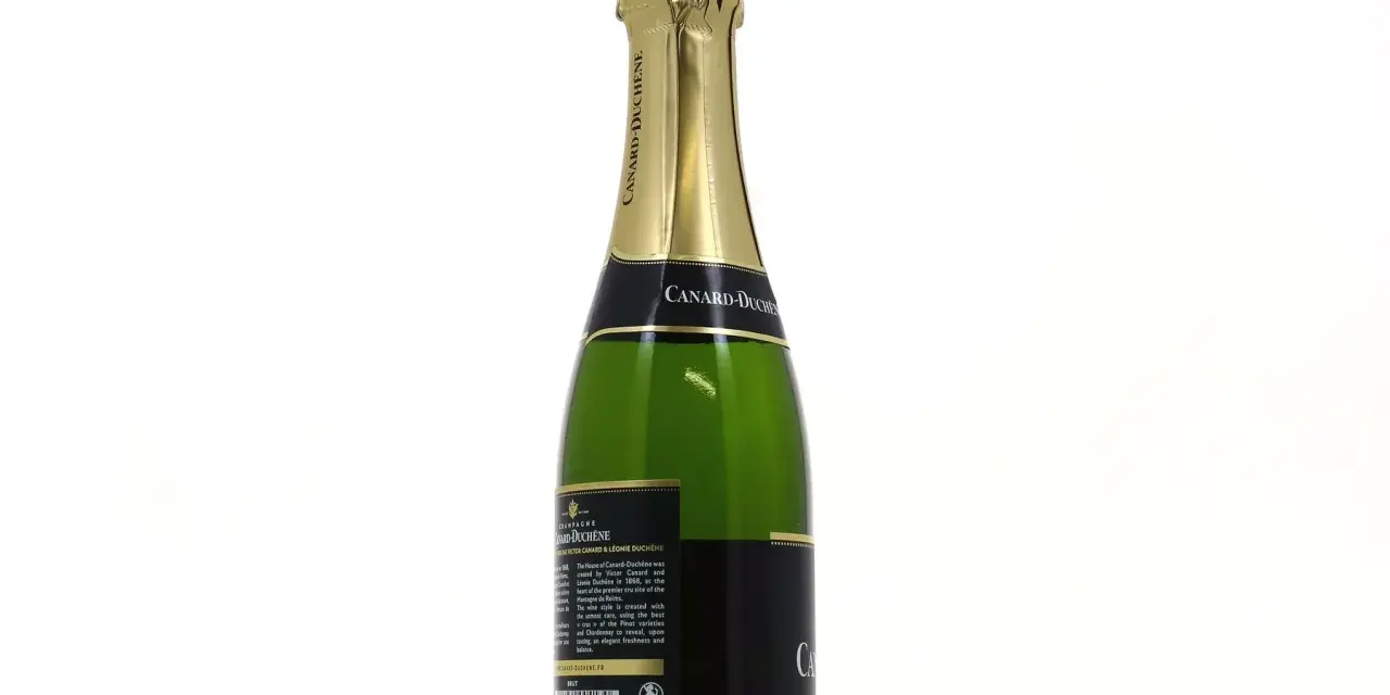 Bouteille de champagne vert Canard-Duchêne avec étiquette noire et dorée, sur fond blanc.