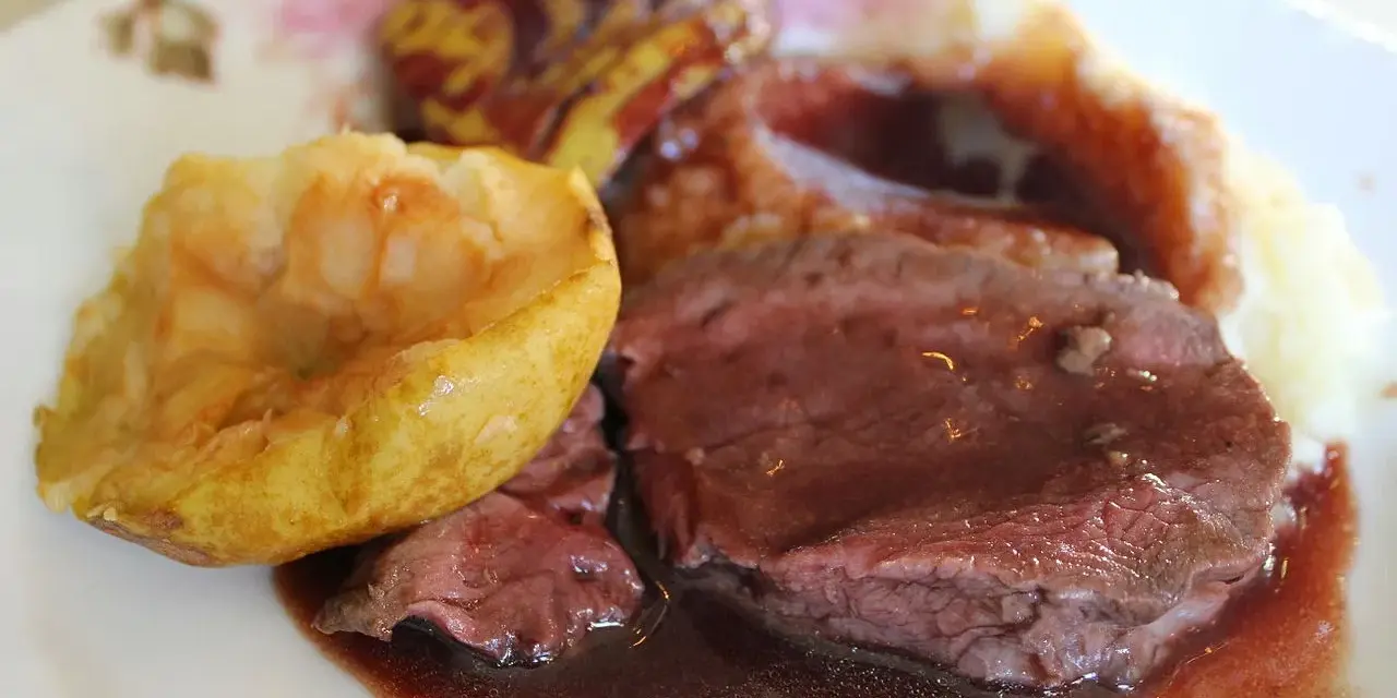Tranches de chevreuil en sauce avec purée et pomme rôtie.
