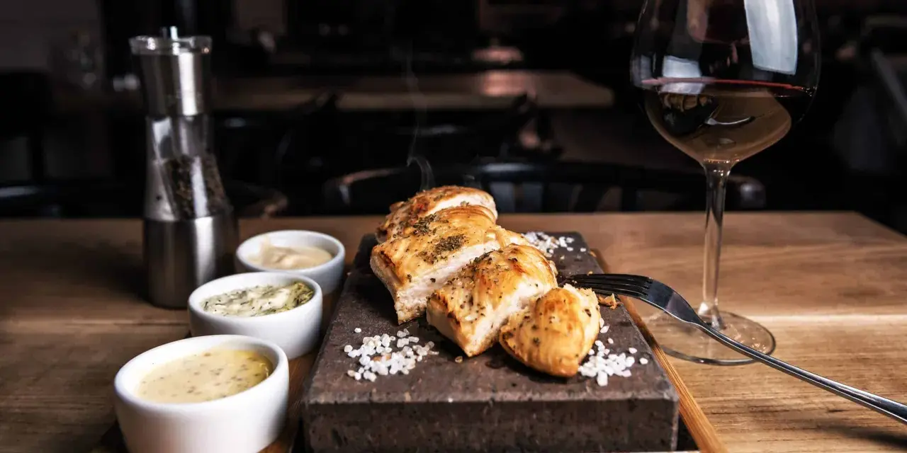 Un plat de viande blanche savoureux, servi avec trois sauces et un verre de vin rouge. La question est : quel vin avec viande blanche ?