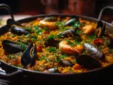 Paella au poulet et fruits de mer, garnie de persil frais. Quel vin rouge avec paella poulet fruits mer ? Un plat savoureux.
