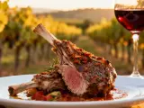 Un plat d'agneau rôti avec une sauce savoureuse, accompagné d'un verre de vin rouge, dans un décor de vignoble. Idéal pour savoir quel vin avec agneau.