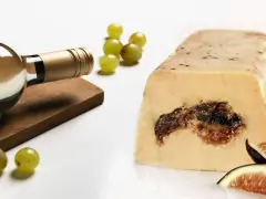 Une bouteille de vin blanc, des raisins et des figues accompagnent ce foie gras. La question est : que boire avec du foie gras ?