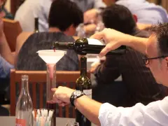 Dégustation de vin rouge, un homme verse du cépage Syrah, d'origine française, dans un verre gradué.