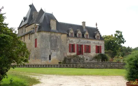 Le **château Olivier**, une bâtisse de pierre aux volets rouges, se dresse fièrement entouré de verdure.