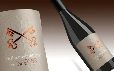Comment reconnaître un bon vin par sa bouteille : une étiquette texturée avec des clés dorées et le texte "Visiblement différent by INES&SENS".