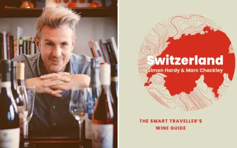 Un homme souriant pose devant des bouteilles de vin, à côté d'une carte de la Suisse stylisée, annonçant un guide sur le vin suisse.