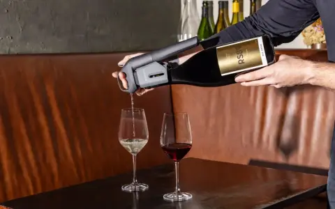 Un appareil verse du vin rouge dans un verre, à côté d'un verre de vin blanc. Parfait pour choisir entre vin rouge, blanc ou rosé.