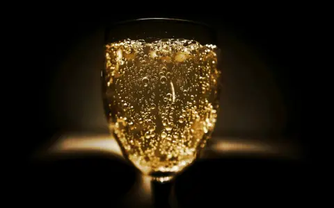Un verre de vin mousseux scintillant, rempli de bulles dorées, prêt à célébrer.
