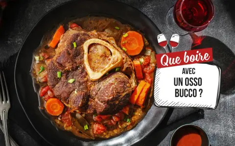 Un osso bucco savoureux, garni de carottes et de tomates, servi avec un verre de vin rouge. Que boire avec un osso bucco ?
