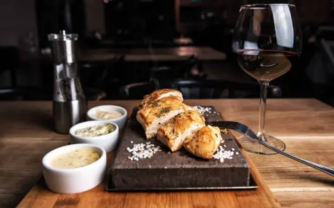 Un plat de viande blanche savoureux, servi avec trois sauces et un verre de vin rouge. La question est : quel vin avec viande blanche ?