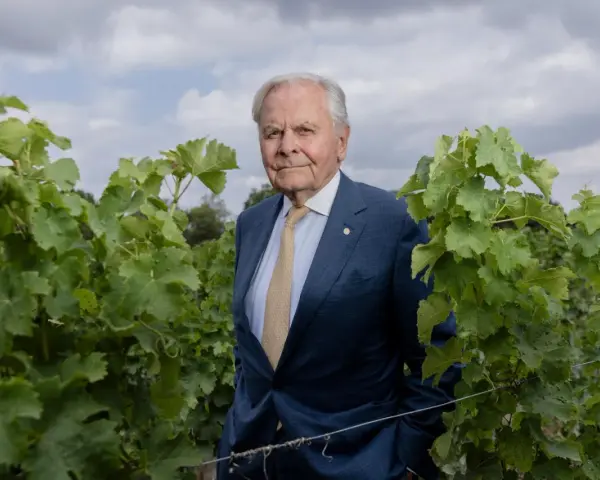 Bernard Magrez, un homme d'affaires visionnaire, pose au milieu de ses vignes luxuriantes, un symbole de son héritage viticole.