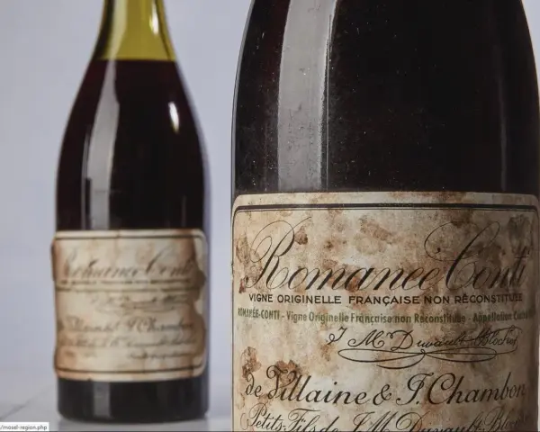 Deux bouteilles de vin Romanée-Conti, dont une avec une étiquette ancienne et jaunie.