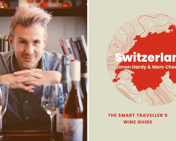 Un homme souriant pose devant des bouteilles de vin, à côté d'une carte de la Suisse stylisée, annonçant un guide sur le vin suisse.