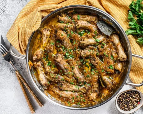 Un plat de poularde mijotée, garnie d'herbes fraîches. Quel vin avec une poularde ? Un blanc sec ou un rouge léger serait parfait.