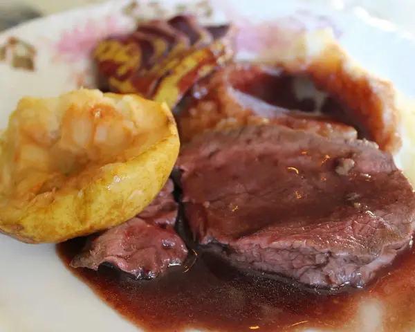 Tranches de chevreuil en sauce avec purée et pomme rôtie.