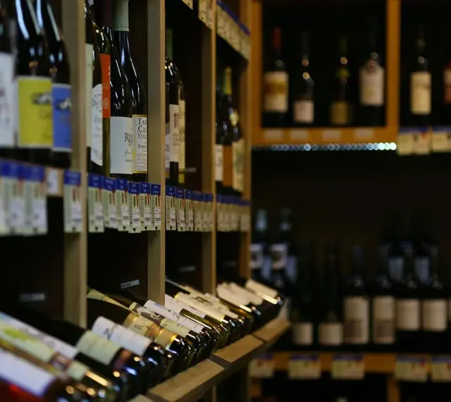 Rayons de bouteilles de vin, prêtes pour la foire aux vins. Des étiquettes colorées et des prix invitent à la dégustation.