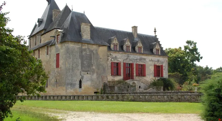 Le **château Olivier**, une bâtisse de pierre aux volets rouges, se dresse fièrement entouré de verdure.