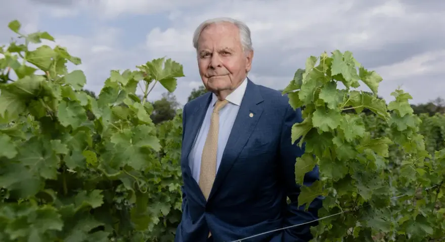 Bernard Magrez, un homme d'affaires visionnaire, pose au milieu de ses vignes luxuriantes, un symbole de son héritage viticole.