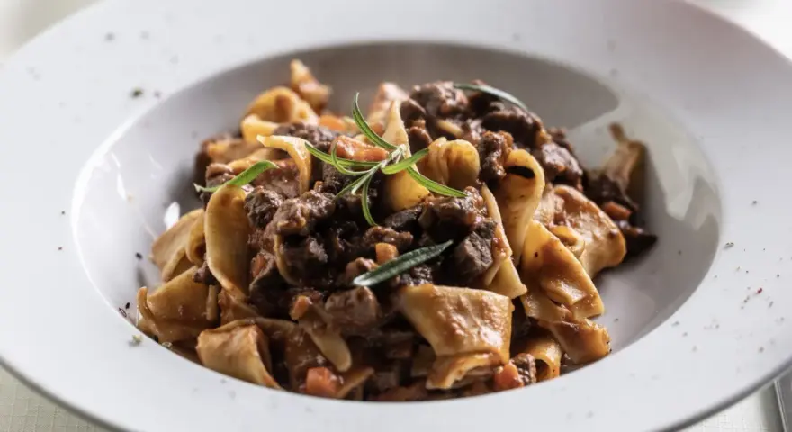 Pâtes fraîches avec un riche civet de bœuf mijoté dans du vin rouge, garni de romarin. Un plat réconfortant parfait pour les soirées d'automne.