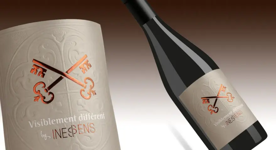 Bouteille de vin avec étiquette ornée de clés croisées, évoquant le pays d'Oc. "Visiblement différent" par INES&SENS.