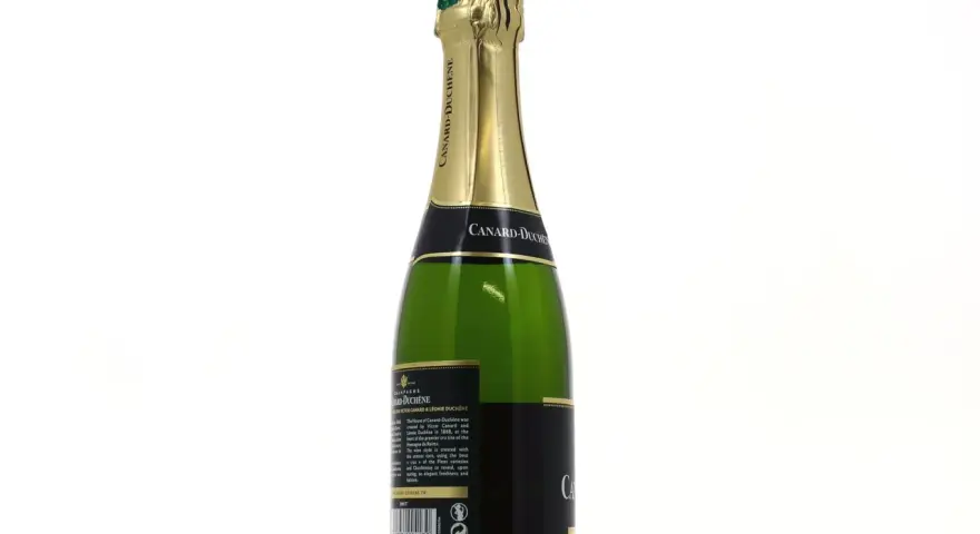 Bouteille de champagne vert Canard-Duchêne avec étiquette noire et dorée, sur fond blanc.