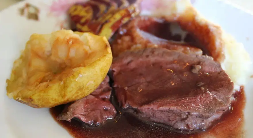 Tranches de chevreuil en sauce avec purée et pomme rôtie.