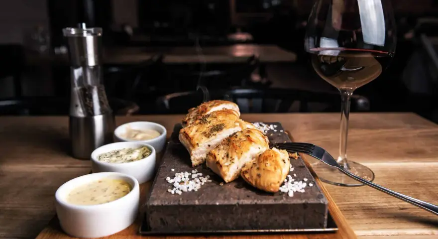 Un plat de viande blanche savoureux, servi avec trois sauces et un verre de vin rouge. La question est : quel vin avec viande blanche ?