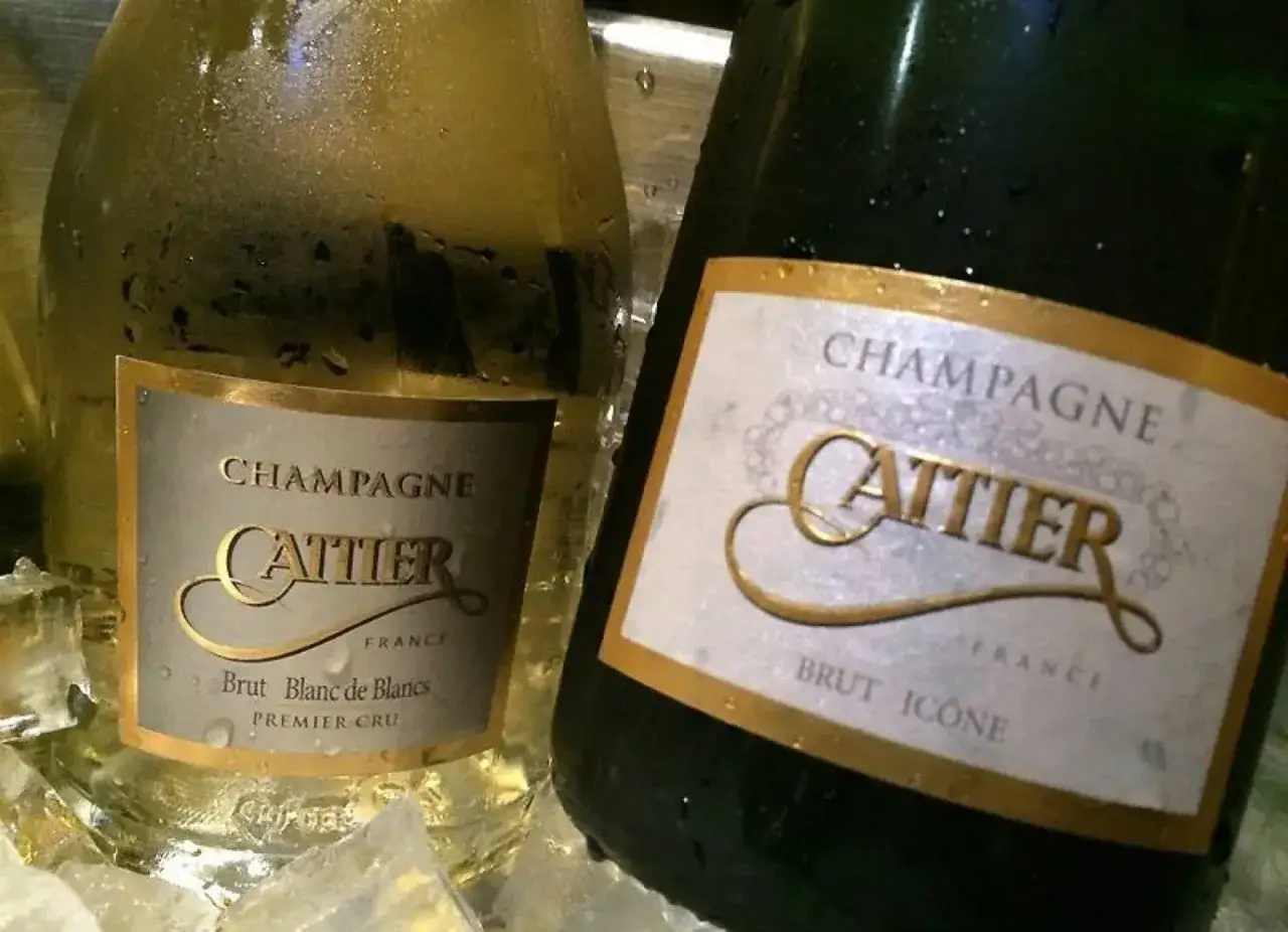 Deux bouteilles de champagne Cattier, Brut Blanc de Blancs et Brut Icône, refroidissent dans la glace. Un avis sur ce champagne est très positif.