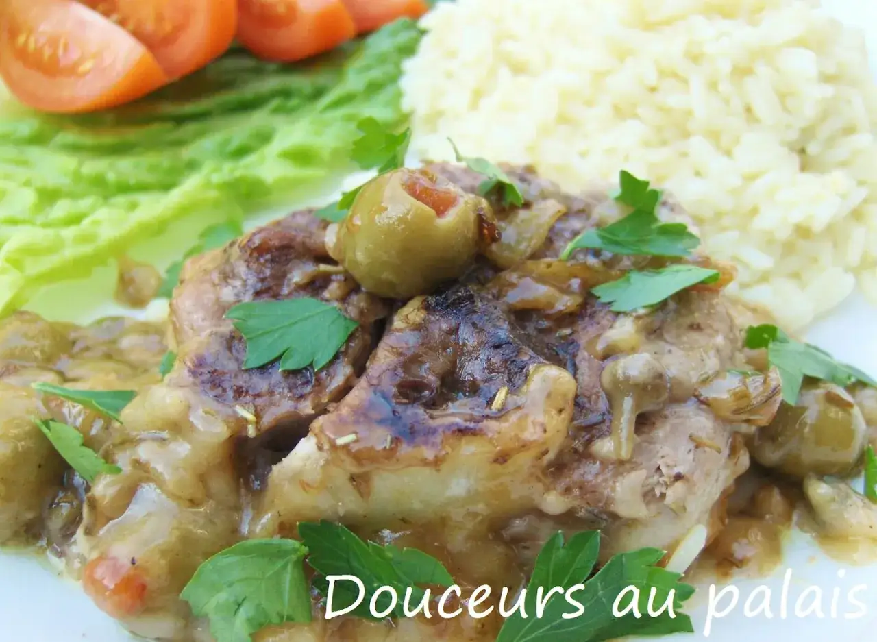 Osso bucco savoureux, garni d'olives et de persil, servi avec du riz et des tomates. Un d&eacute;lice qui se marie aussi bien avec du vin rouge qu'avec du blanc.