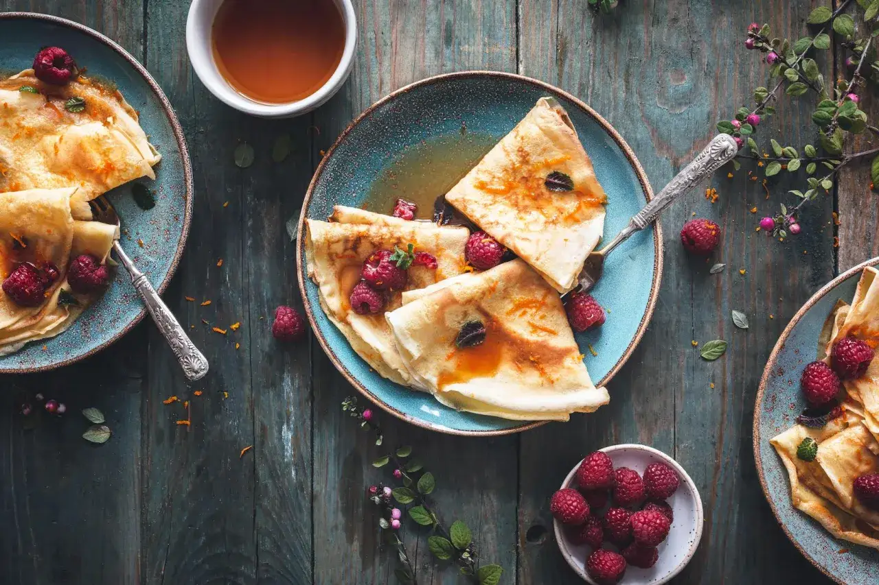Cr&ecirc;pes sucr&eacute;es aux framboises, arros&eacute;es de sirop. Parfait pour savoir que boire avec des cr&ecirc;pes sucr&eacute;es.