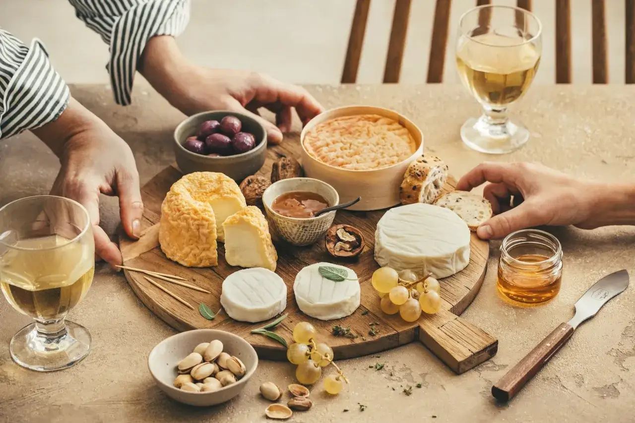 Un plateau de fromages vari&eacute;s avec olives, noix, raisins et miel. Une question se pose : quel vin avec le fromage pour sublimer cette d&eacute;gustation ?