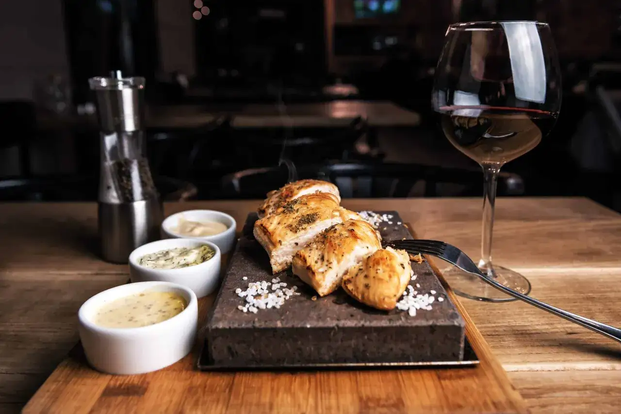 Un plat de viande blanche savoureux, servi avec trois sauces et un verre de vin rouge. La question est : quel vin avec viande blanche ?