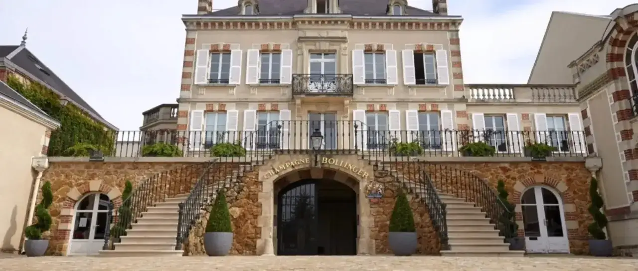 Le majestueux bâtiment de Champagne Bollinger, avec ses escaliers en pierre et son arche ornée du nom de la marque. Un avis sur ce champagne prestigieux s'impose.