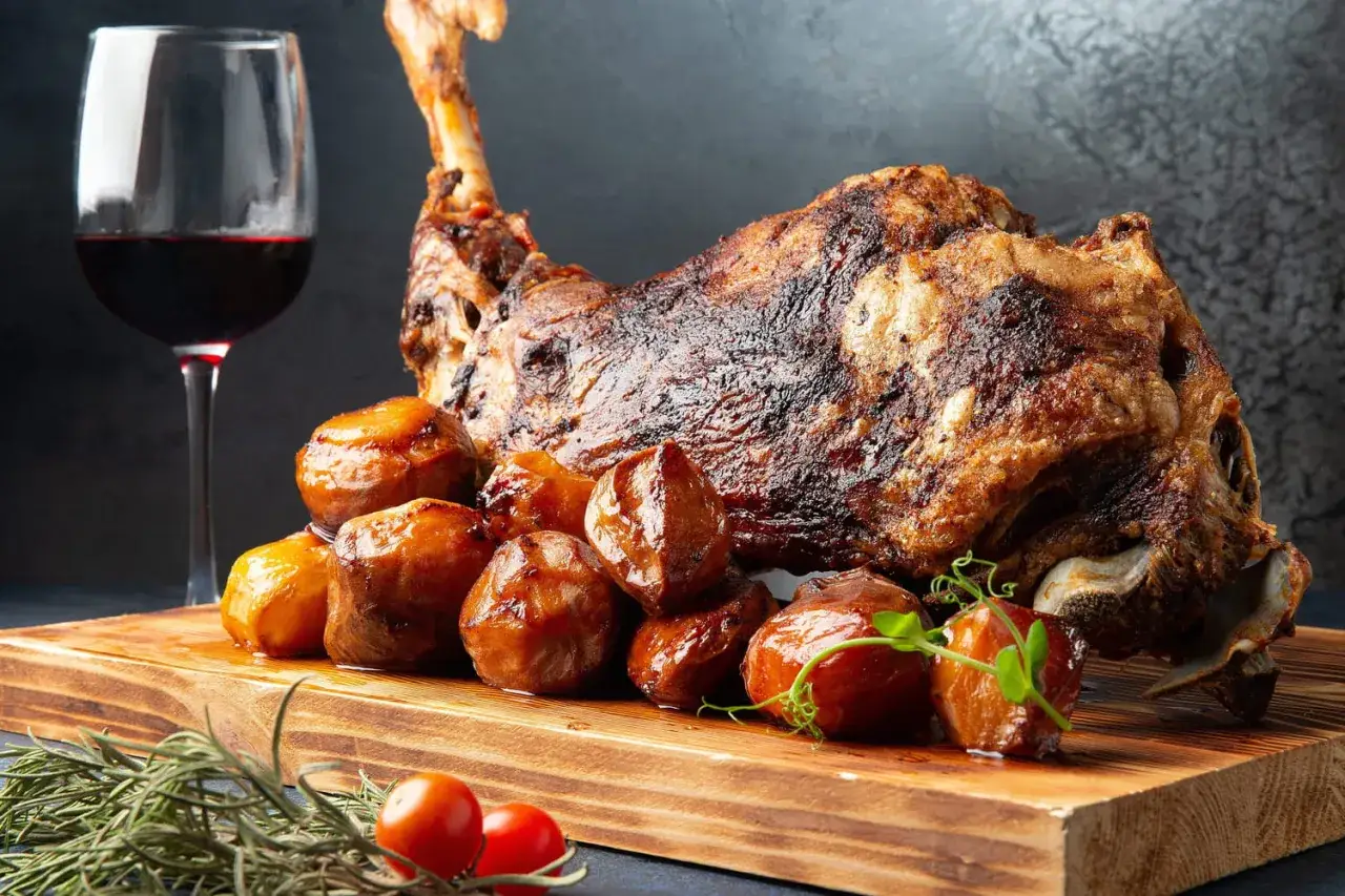 Gigot d'agneau r&ocirc;ti, pommes de terre grenaille et un verre de vin rouge. Le choix parfait pour savoir que boire avec un gigot d'agneau.