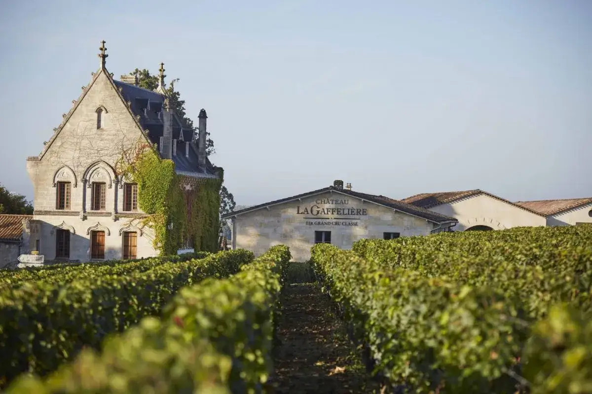 Le Ch&acirc;teau La Gaffeli&egrave;re, un Premier Grand Cru Class&eacute;, se dresse fi&egrave;rement au milieu de ses vignobles verdoyants sous un ciel clair.