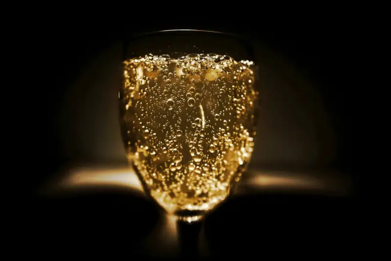 Un verre de vin mousseux scintillant, rempli de bulles dorées, prêt à célébrer.